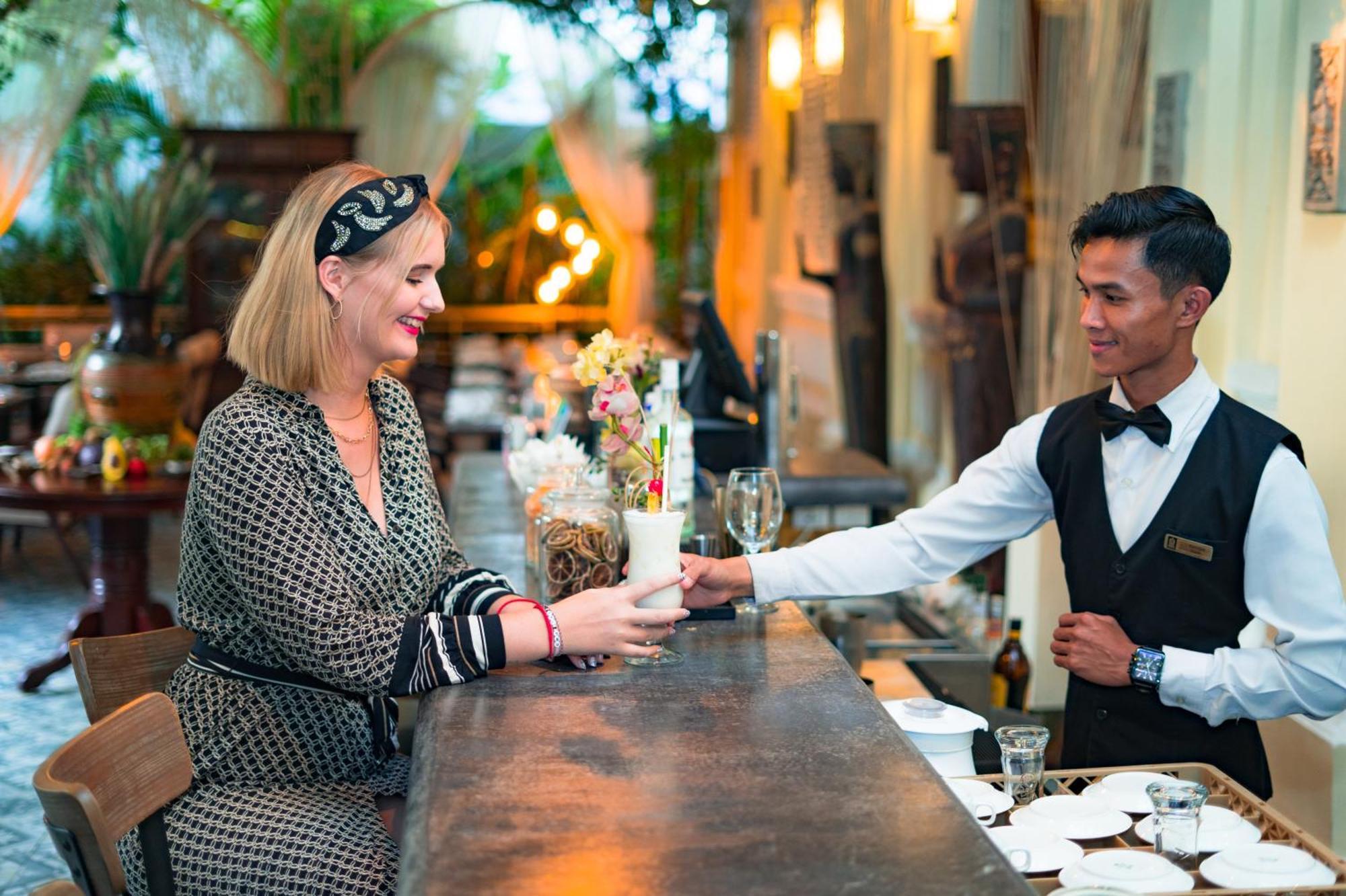 Palace Gate Hotel & Resort By Ehm Пном Пен Екстериор снимка A guest being served at the bar